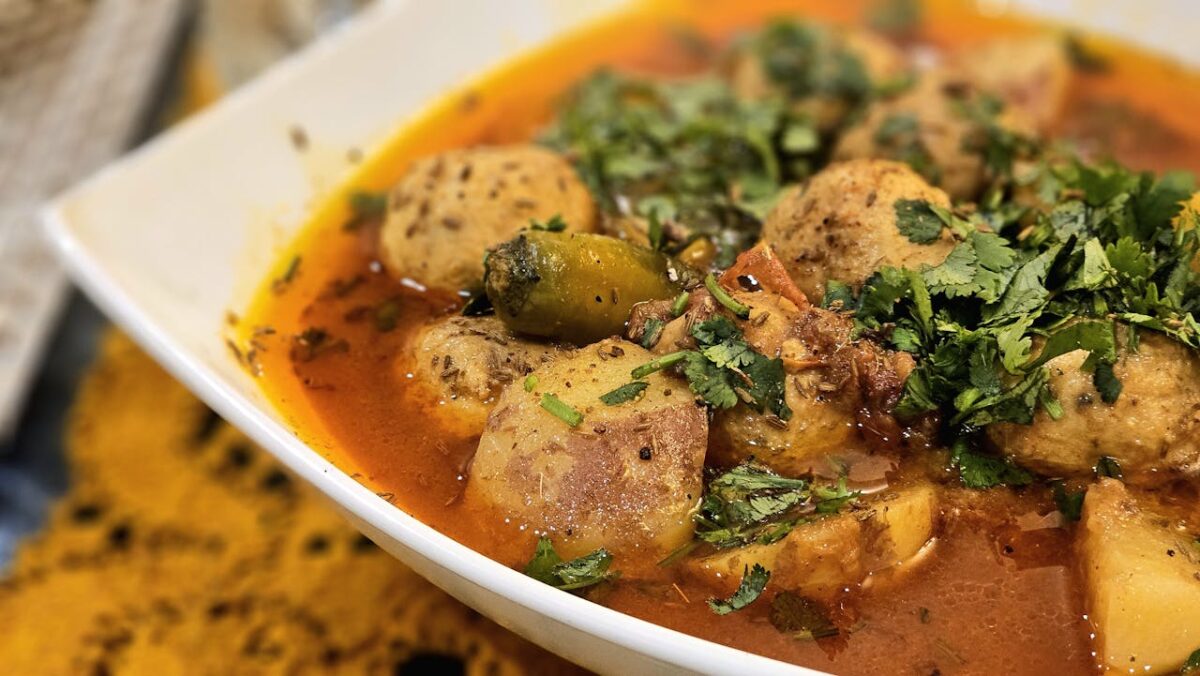 A delicious bowl of spicy potato curry garnished with fresh cilantro, served warm.