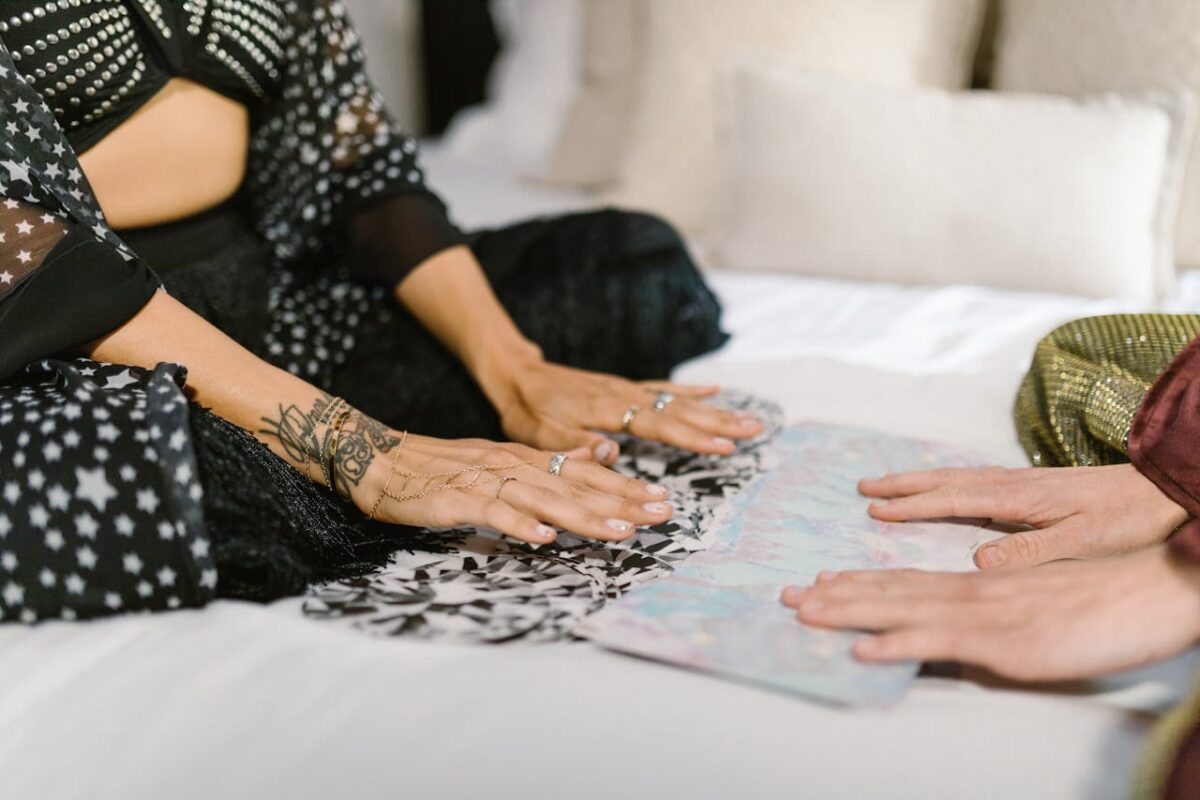 Intimate tarot card reading session with two adults sitting on a bed, focusing on spiritual awakening.